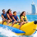 Family and friends enjoying an exciting banana boat ride on the water near Palm Jumeirah in Dubai