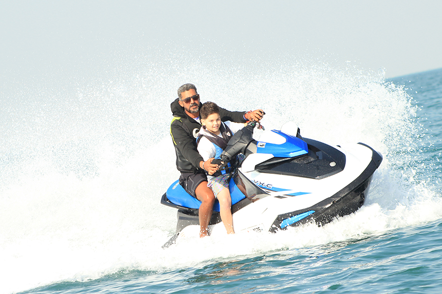 Friends enjoying jet skiing, donut rides, and other water sports near Palm Jumeirah in Dubai